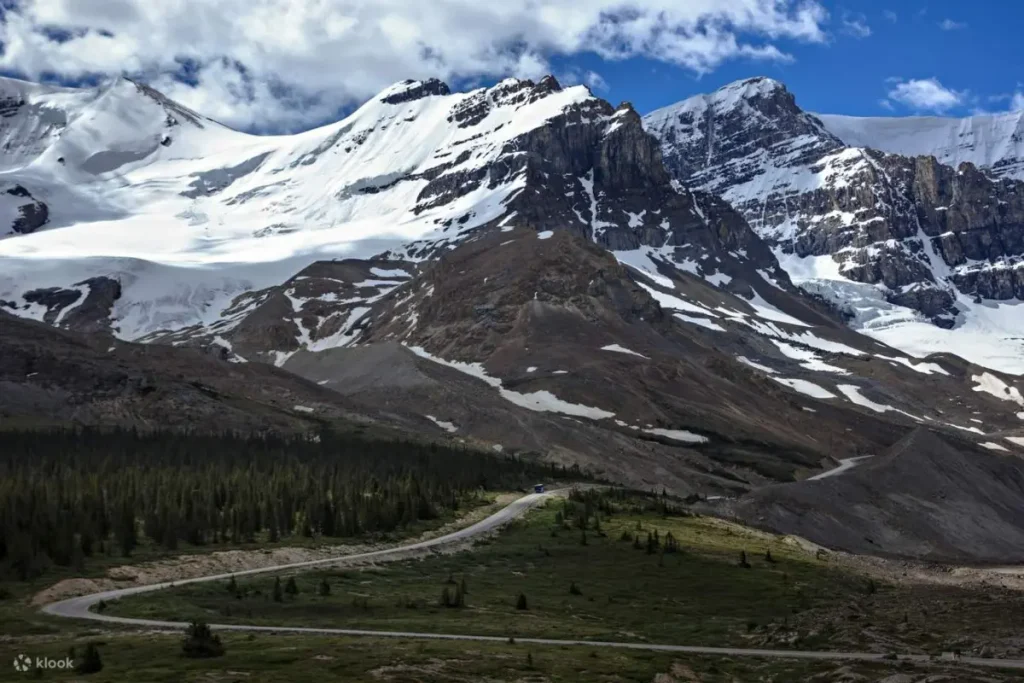Winding highway along the Icefields Parkway near Banff with dramatic snow-capped peaks and glaciers in the Canadian Rockies