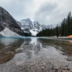 Landscape comparison for Lake Louise vs. Moraine Lake tours featuring turquoise waters and snow-capped mountain peaks in Banff National Park