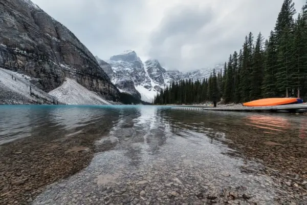Landscape comparison for Lake Louise vs. Moraine Lake tours featuring turquoise waters and snow-capped mountain peaks in Banff National Park