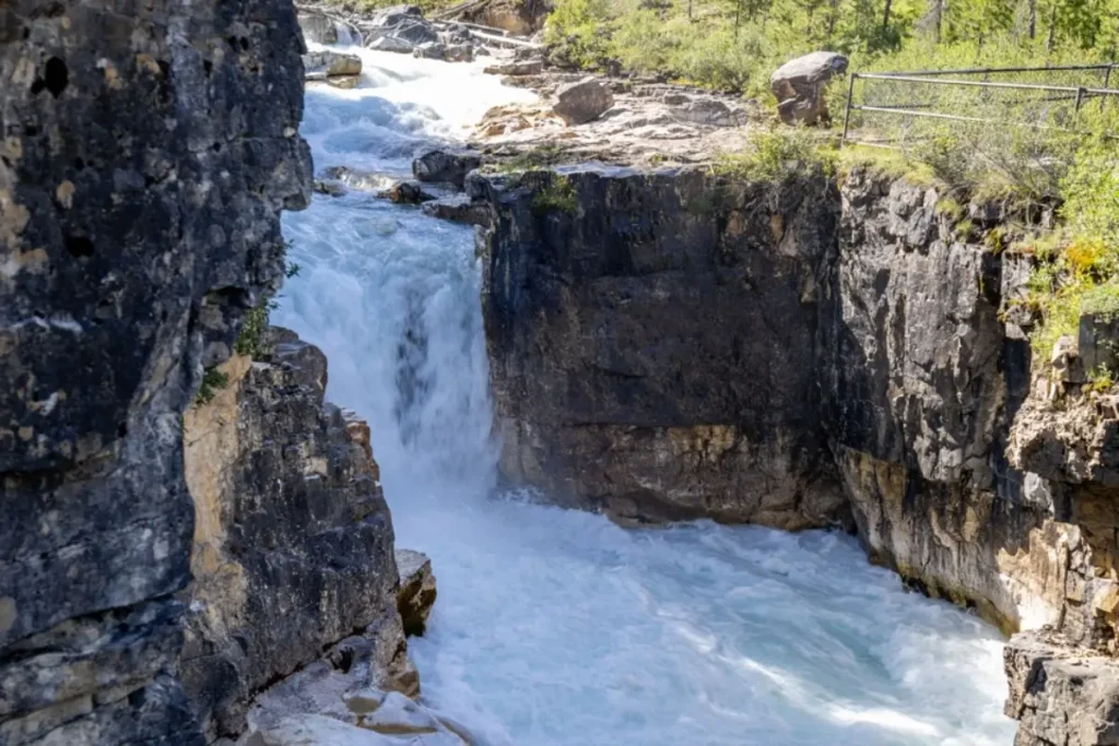 Whitewater cascade rushing through rocky gorge walls in olive lake and sinclair canyon kootenay national park